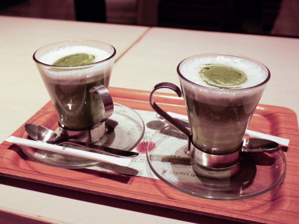 Two green tea lattes on a tray